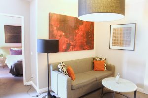 Adina Apartment Hotel,grey couch, orange painting, berlin, checkpoint charlie